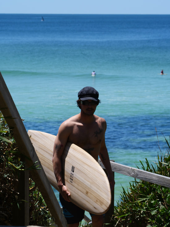 Cool surfer at beach with sustainable hollow wooden surfboard